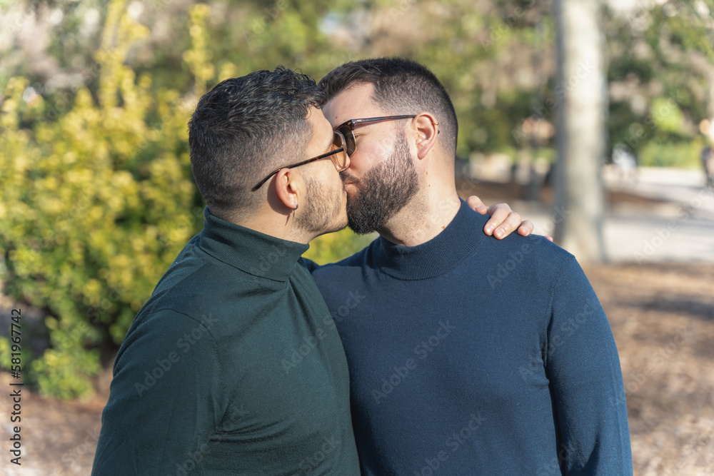 gay couple in the park, with sunglasses, affectionate and playful gay couple in the park, with sunglasses, affectionate and playful