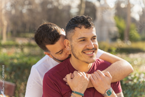 gay couple in the park, cuddling, loving and playful