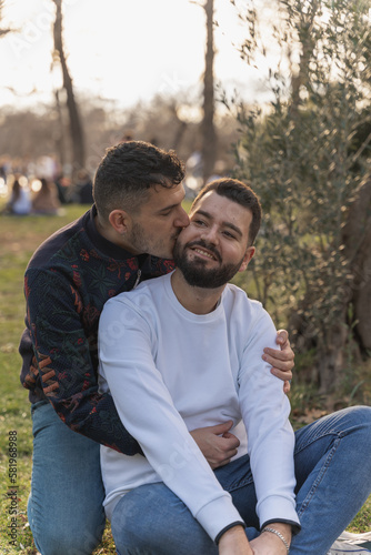 gay couple in the park, cuddling, loving and playful