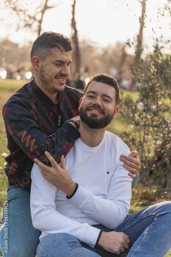 gay couple in the park, cuddling, loving and playful