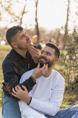 gay couple in the park, cuddling, loving and playful