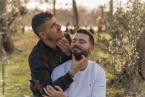 gay couple in the park, cuddling, loving and playful