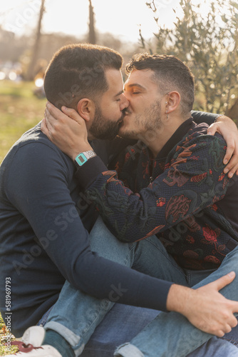 gay couple in the park, cuddling, loving and playful