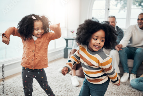 Children dancing, living room and happy family with parents, grandparents or love for comic smile in home. Kids, men and women for dance, care and happiness for brother, sister or together on holiday