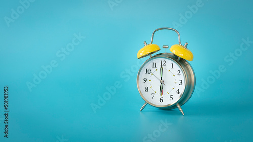 Retro silver alarm clock. 6:00, am, pm. Blue background.