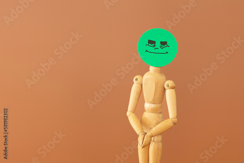 Принти на полотні Wood model with maliciousness and malevolence concept, on brown background