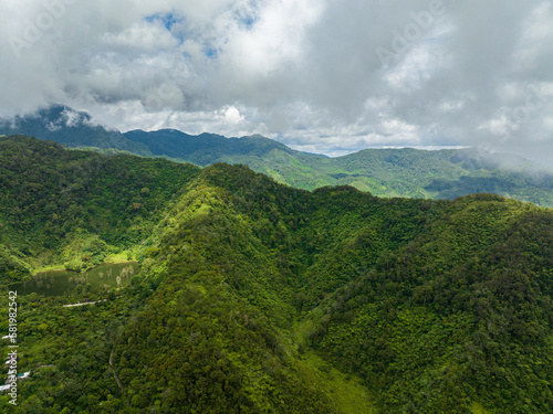 Aerial view of mountains and hills with green forest and clouds. Negros, Philippines
