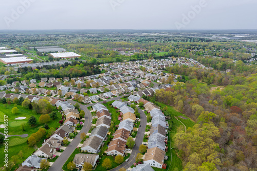 There is large residential complex district on an aerial panoramic view with spring trees and residential district in small American town.