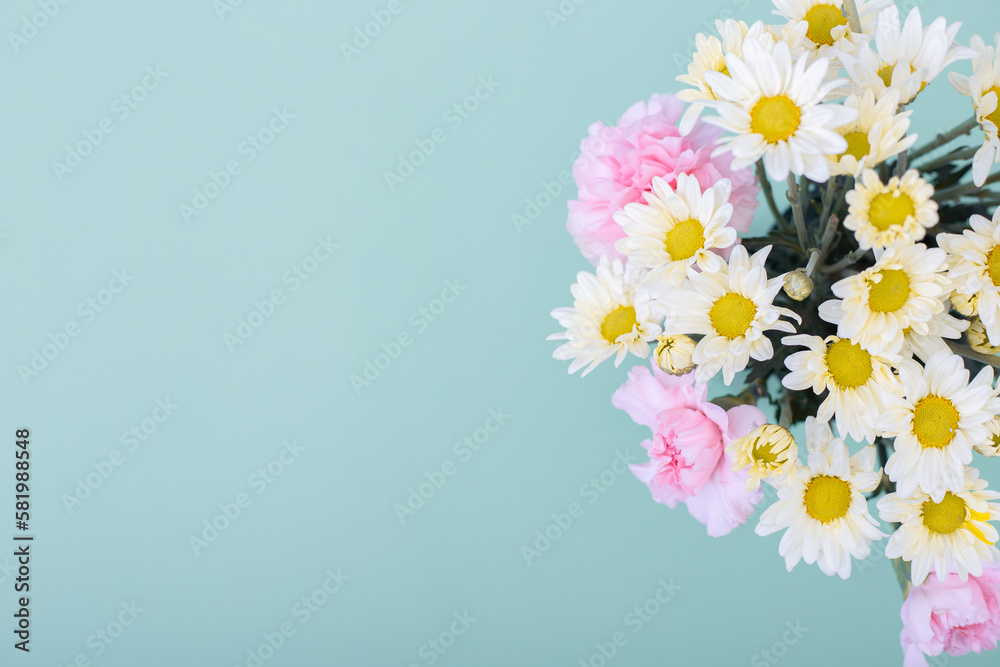 Ramo de flores de margaritas blancas y claveles rosa sobre fondo de color azul ideal para banners de ofertas, avisos de primavera