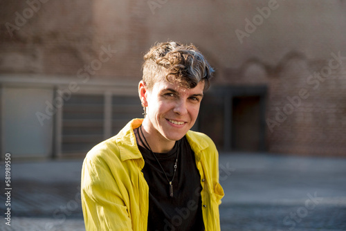 Portrait of a non binary person looking at camera while posing outdoors. photo