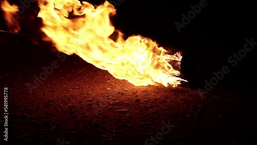 Props, inventory for the fire show. Evening show program on the street. Burning Spark staff with kerosene. Slow motion.