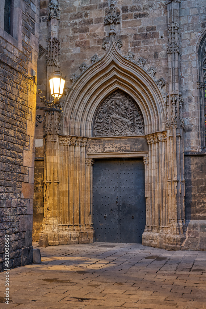 Street in the Gothic Quarter in Barcelona at twilight with a side entrance to the cathedral