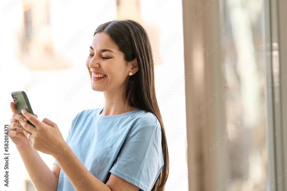 Woman laughing while using a mobile phone outdoors Woman laughing while using a mobile phone outdoors