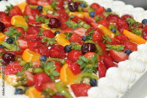 Close up of a white fruit cake at a wedding.