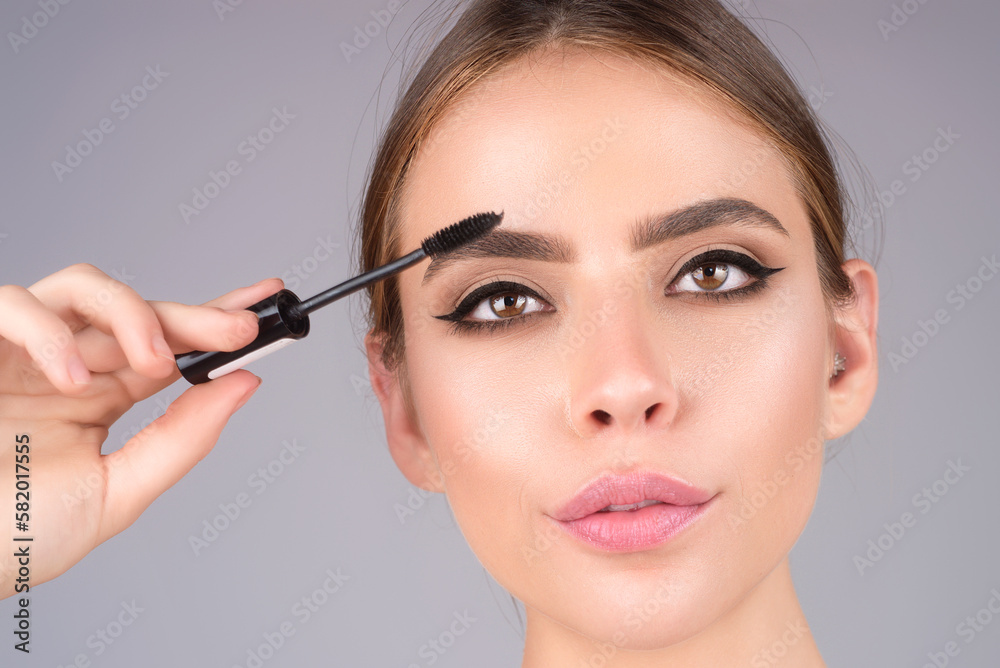 Female model shaping brown eyebrows. Woman eye with beautiful eyebrows. Perfect shaped brow, eyelashes with brow gel brush. Paint eyebrows.