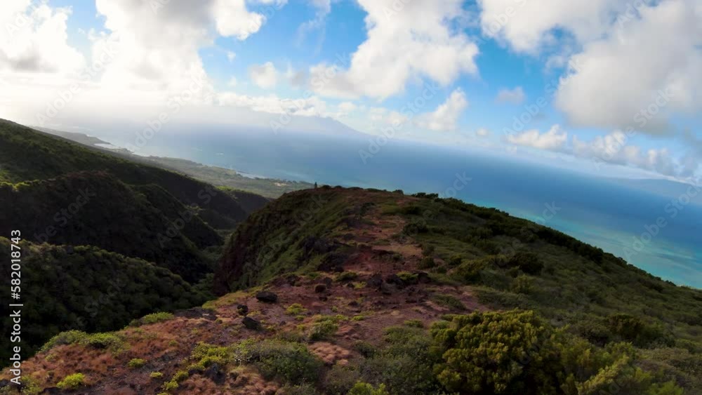 Experience Hawaii's sustainable ecotourism paradise from above, with stunning FPV aerial view of green mountains revealing waterfalls and blue ocean in Molokai, Hawaii. Experience Hawaii's sustainable ecotourism paradise from above, with stunning FPV aerial view of green mountains revealing waterfalls and blue ocean in Molokai, Hawaii.