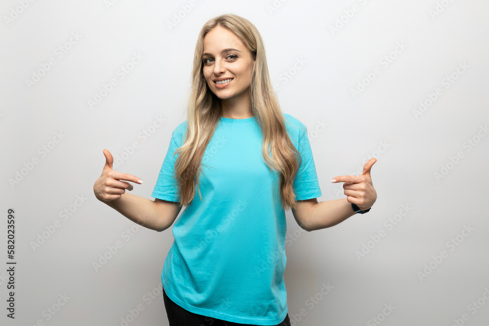 young woman shows her hands on a T-shirt on a white background young woman shows her hands on a T-shirt on a white background
