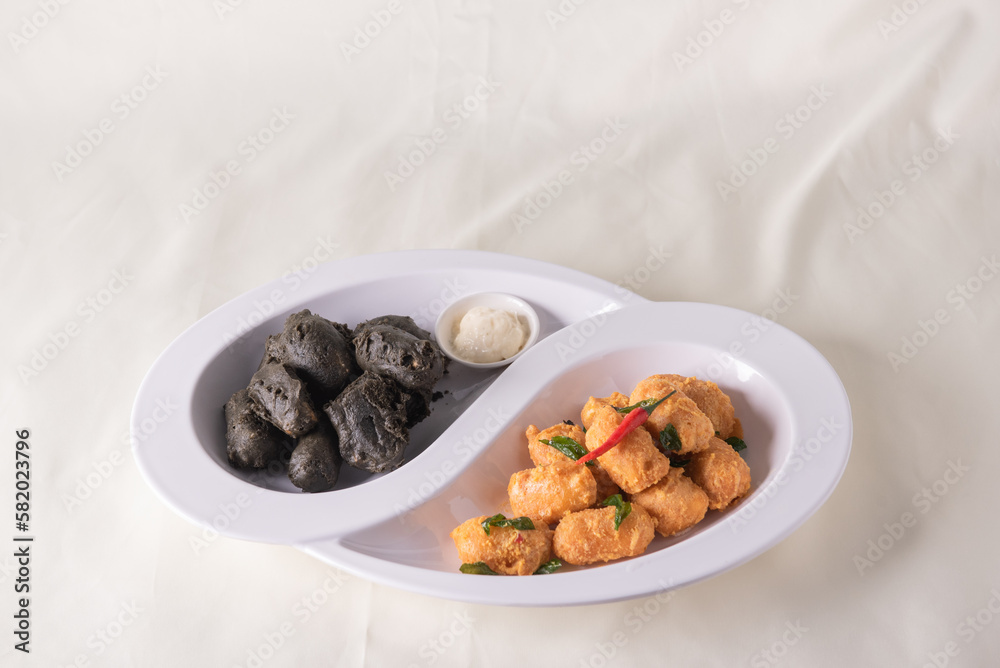 dou style deep fried crispy seafood beancurd black and white tofu in salted egg yolk sauce and mayonnaise sauce on wood table asian halal banquet appetiser snack salad menu 