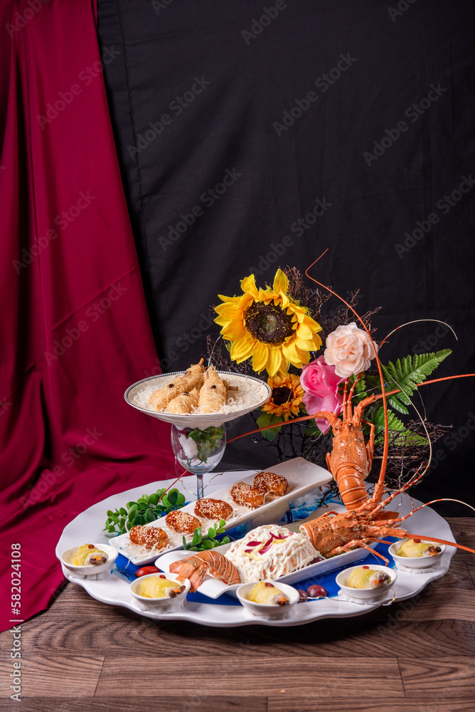 beautiful Deluxe Lobster Big cold Platter Combination with deep fried prawn honey chicken wing lobster salad herbal dim sum roll in flower plate decor on wood table asian banquet appetiser halal menu