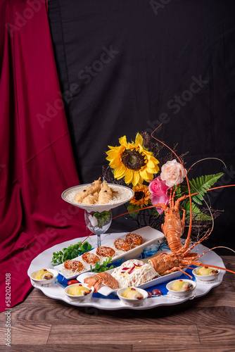 beautiful Deluxe Lobster Big cold Platter Combination with deep fried prawn honey chicken wing lobster salad herbal dim sum roll in flower plate decor on wood table asian banquet appetiser halal menu