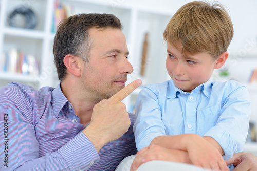 Man pointing finger at young child
