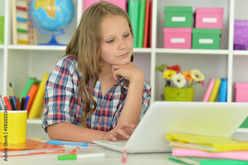 girl using laptop at desk at home girl using laptop at desk at home