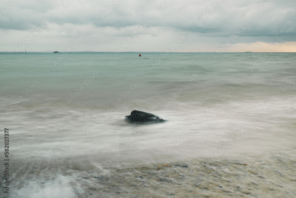 long exposure shot of rocks in the calm sea long exposure shot of rocks in the calm sea