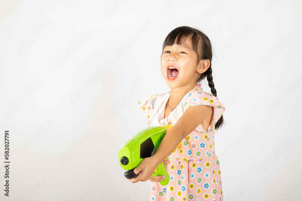Happy Songkran Day, Asian little girl holding plastic water gun, Thai child funny hold toy water pistol and smile, isolated on white background, Thailand Songkran festival national culture concept Happy Songkran Day, Asian little girl holding plastic water gun, Thai child funny hold toy water pistol and smile, isolated on white background, Thailand Songkran festival national culture concept