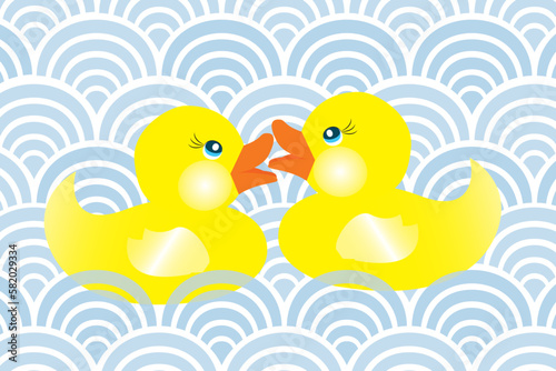 Two cute little rubber ducks in love swimming in blue waves