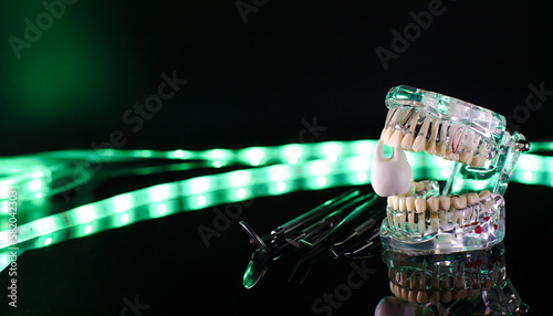 Dental tools and model of teeth on a neon background. Dental care concept. Invisible braces