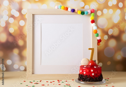 The number Seven on the yellow cake next to the white frame mockup with copy space
