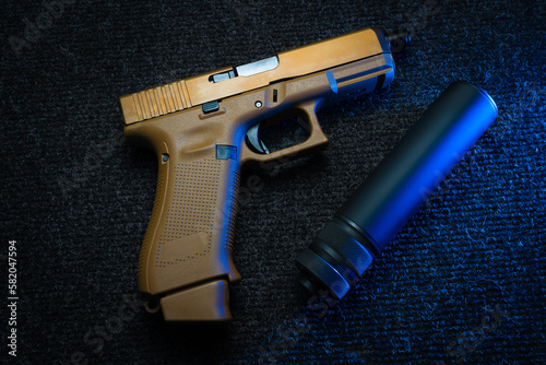 A sand camouflage pistol and a compact silencer. photo