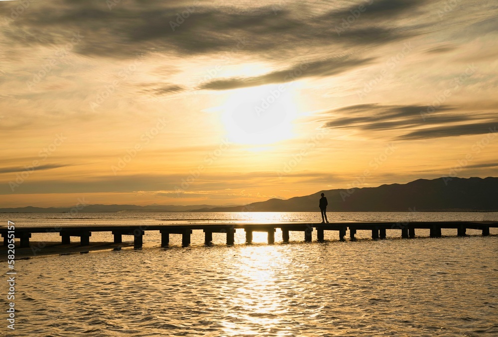 Silhouette of people looking at the dock at sunset in the Delta Ebro. Spain