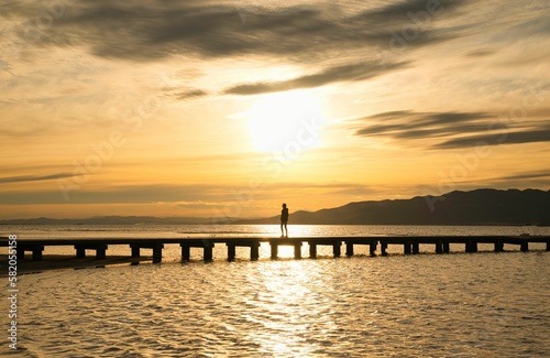 Silhouette of people looking at the dock at sunset in the Delta Ebro. Spain