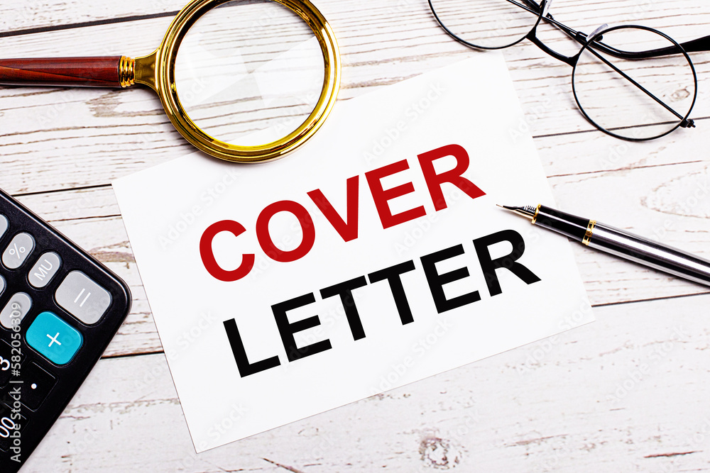 Φωτογραφία A workplace with a pen, glasses, a calculator, a magnifying glass and a white sheet of paper with the text of the COVER LETTER on a white wooden table