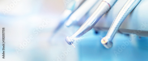 Closeup photo of dental handpieces and equipment on dental chair with blured background.