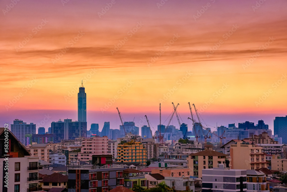 Obraz premium Colorful sunset over big city, downtown skyline and residential area.