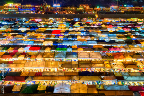 Colorful rows of night outdoor market tents and food stalls in Asia. 