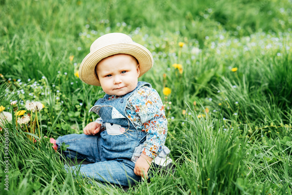 cute and cheerful portrait of little child sitting in blooming flowers of dandelion. concept nature and imagination. honey allergy. summer mood cute and cheerful portrait of little child sitting in blooming flowers of dandelion. concept nature and imagination. honey allergy. summer mood