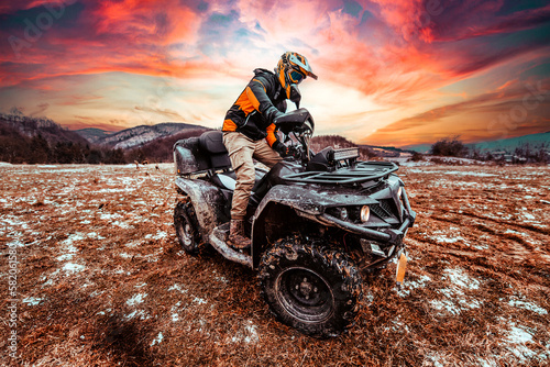 Fototapeta Naklejka Na Ścianę i Meble -  A man drives an ATV in the mud. Drift driving an ATV quad in mud and snow