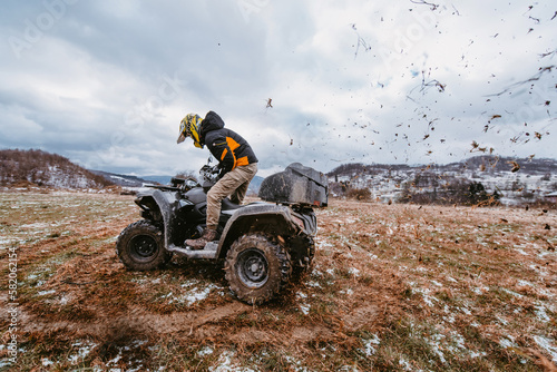A man drives an ATV in the mud. Drift driving an ATV quad in mud and snow