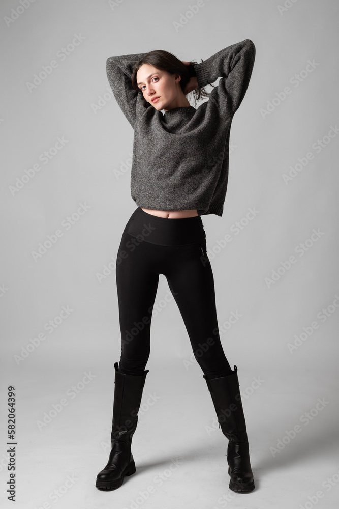Sexy young woman standing against grey studio background Stock Photo