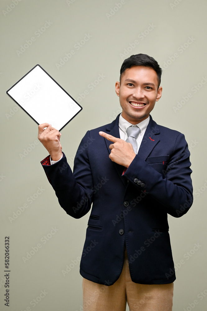 Asian businessman pointing his finger at a tablet while standing against an isolated background Asian businessman pointing his finger at a tablet while standing against an isolated background