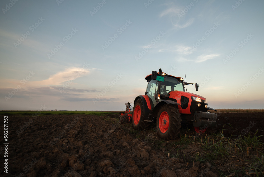 Tractor on the field during sunset. Tractor on the field during sunset.