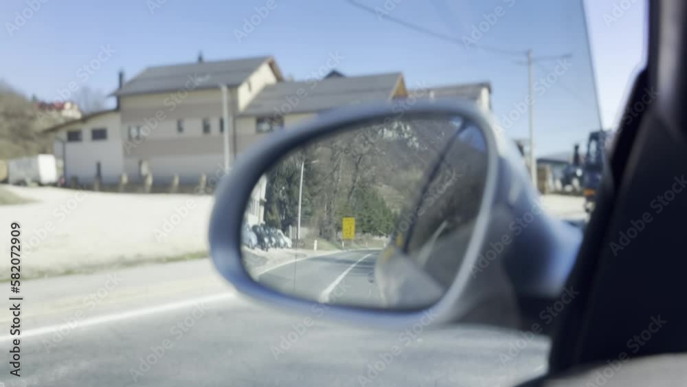 View of the road in the rearview mirror of a car at sunset View of the road in the rearview mirror of a car at sunset