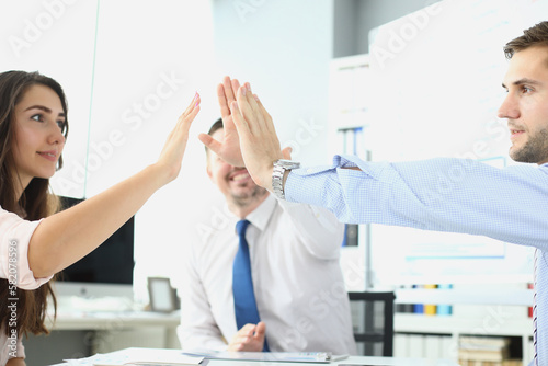 Successful business ladies in office at their desk give each other five hands