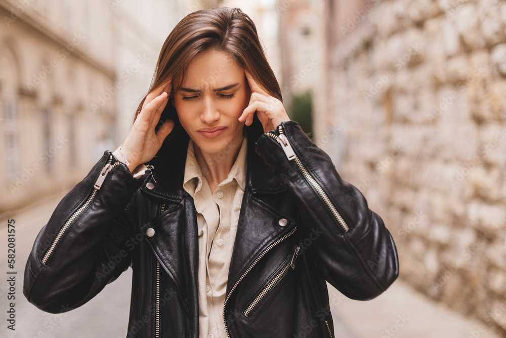 Panic attack on the street. Female touch her head with her hands as she stands in the street. Female feeling headache on the street. Stressed woman outside. Panic attack on the street. Female touch her head with her hands as she stands in the street. Female feeling headache on the street. Stressed woman outside.