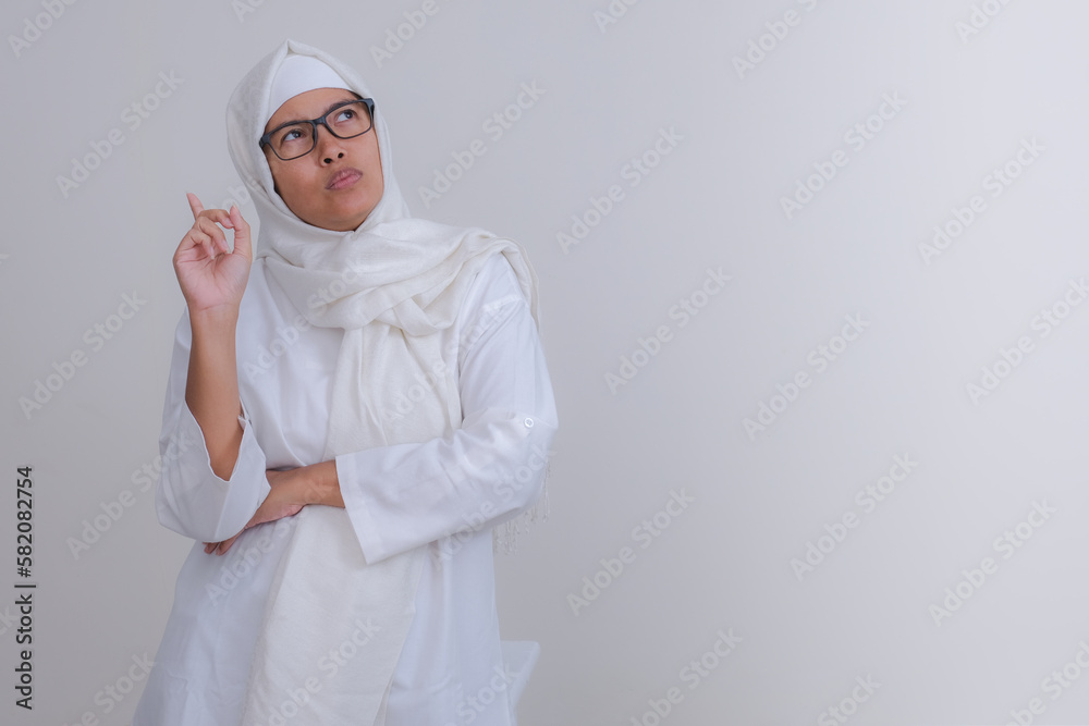 A young woman wearing a hijab with an expression remembering something A young woman wearing a hijab with an expression remembering something