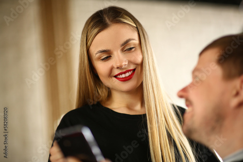 Man shows hair stylist to woman on phone