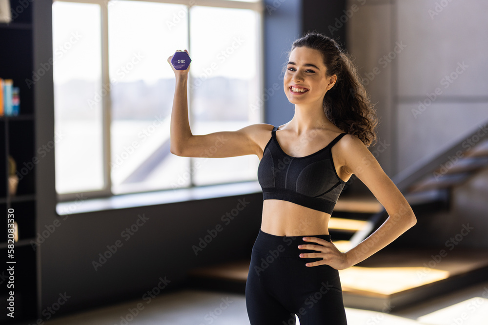 Determined woman losing weight at home and exercising with dumbbells. Determined woman losing weight at home and exercising with dumbbells.
